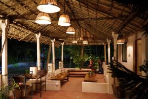 an outdoor patio with tables and chairs and lights at Terraria Stay and Cafe in Canacona
