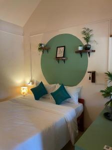 a bedroom with a large bed with a green headboard at Terraria Stay and Cafe in Canacona