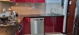 a small kitchen with red cabinets and a sink at On320 Residencies in Colombo