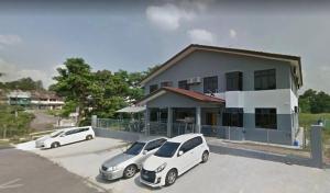 tres autos estacionados en un estacionamiento frente a un edificio en Rahmah Sojourn Center en Johor Bahru