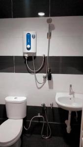 a bathroom with a white toilet and a sink at Rahmah Sojourn Center in Johor Bahru