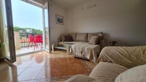 uma sala de estar com um sofá e uma varanda em Apartments Marin - amazing sea view em Splitska