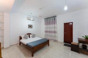 ein Schlafzimmer mit einem Bett und einem TV in einem Zimmer in der Unterkunft Gentz Residency & Restaurant in Colombo