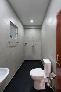 a bathroom with a white toilet and a sink at Gentz Residency & Restaurant in Colombo