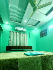 a bedroom with green walls and a bed with a ceiling at RUSHITHA HOME STAY-AC Rooms-FREE WIFI-FLAT TV- KITCHEN-DOOR SERVICE-NEAR TO ALIPIRI in Tirupati