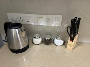 a kitchen counter with a coffee pot and some utensils at 1BHK in Hiranandani Powai A in Mumbai