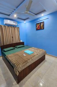a bedroom with a bed in a blue room at RUSHITHA HOME STAY-AC Rooms-FREE WIFI-FLAT TV- KITCHEN-DOOR SERVICE-NEAR TO ALIPIRI in Tirupati