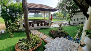 a gazebo with a picnic table in a yard at Ayutthaya teak home Homestay in Phra Nakhon Si Ayutthaya