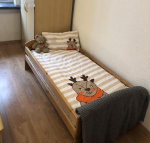 a small bed with three stuffed animals on it at Haus am Wald in Hohndorf