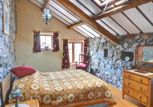 a bedroom with a bed and a stone wall at The Granary in Caernarfon