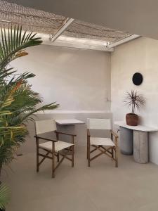 a room with two tables and two chairs and a plant at AMBERGRIS in Liên Trì (3)