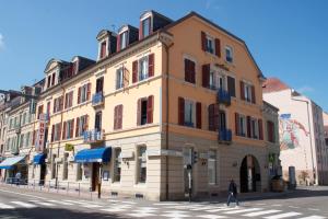 un edificio en la esquina de una calle de la ciudad en Hotel Restaurant Les Capucins en Belfort