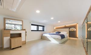 una camera bianca con un letto e una finestra di Dal Bodre Pool & Spa Pension a Pohang