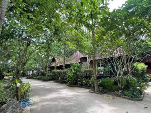 una casa con muchos árboles delante de ella en ้hilly phitsano resort, 