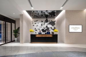 two people sitting at a reception desk in a lobby at Citadines Yunlong Lake Xuzhou in Xuzhou