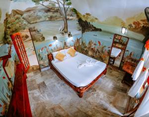 Schlafzimmer mit Wandgemälde in der Unterkunft Kokosnuss Garden Resort in Coron