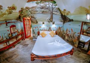 a room with a bed with a painting on the wall at Kokosnuss Garden Resort in Coron