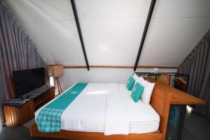 a small bedroom with a bed and a television at Ubu Villa Coconut 102 - in Yogyakarta in Yogyakarta +3 photos