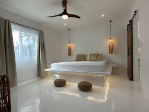 a white bathroom with a tub and a ceiling fan at Pawikan Seaview Villa with breakfast in Moalboal