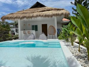 a villa with a swimming pool in front of a house at Pawikan Seaview Villa with breakfast in Moalboal