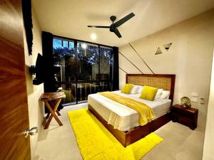 a bedroom with a bed and a large window at *Tulum 2BR w/ Pool, Gym, Security, Walk to Town in Tulum +17 photos