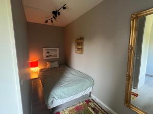 a small bedroom with a bed and a mirror at 180m2 Villa with Jacuzzi, Sauna and Garden in Växjö