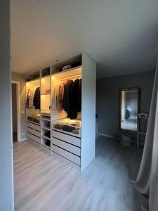 a walk in closet with open cabinets and a mirror at 180m2 Villa with Jacuzzi, Sauna and Garden in Växjö