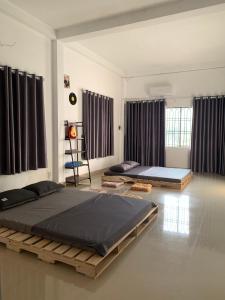 Duas camas num quarto com cortinas em The Vinyl Homestay em Ho Chi Minh