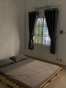 a bed in a room with a window at The Vinyl Homestay in Ho Chi Minh City