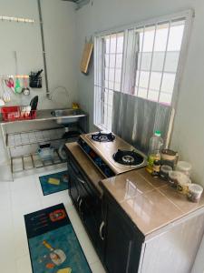 a small kitchen with a stove and a sink at Simple2 Guesthouse in Pantai Cenang