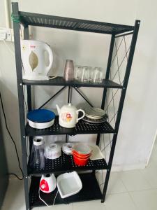 a shelf with dishes and other items on it at Simple2 Guesthouse in Pantai Cenang