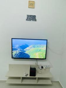 a flat screen tv hanging on a white wall at Simple2 Guesthouse in Pantai Cenang