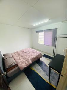 a small bedroom with a bed and a table at Simple2 Guesthouse in Pantai Cenang +16 photos