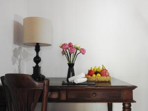 a table with a lamp and flowers and fruit on it at VILLA MASSILIA in Siem Reap
