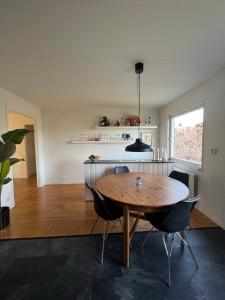 cocina y comedor con mesa de madera y sillas en 180m2 Villa with Jacuzzi, Sauna and Garden, en Växjö