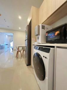 亞庇的住宿－Seaview Studio Apartment at Kota Kinabalu City Centre，厨房配有洗衣机和微波炉。