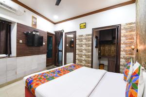 a bedroom with a bed and a flat screen tv at FabExpress New Diamond in Kolkata