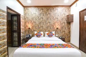a bedroom with a large white bed with colorful pillows at FabExpress New Diamond in Kolkata