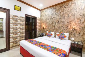 a bedroom with a bed and a stone wall at FabExpress New Diamond in Kolkata