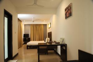 a hotel room with a bed and a desk at Casabela Boutique Hotel in Porvorim