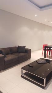 ein Wohnzimmer mit einem braunen Sofa und einem Tisch in der Unterkunft Business Pro Apartment, Windhoek in Windhoek