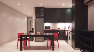 uma cozinha com uma mesa preta e cadeiras vermelhas em Business Pro Apartment, Windhoek em Windhoek