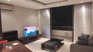 uma sala de estar com um sofá e uma televisão de ecrã plano em Business Pro Apartment, Windhoek em Windhoek