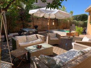 a patio with chairs and an umbrella and a pool at Résidence Guddelmoni in Propriano