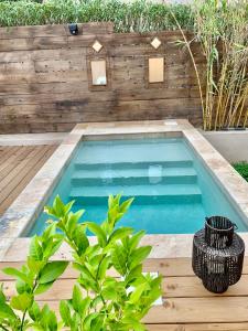 a swimming pool in a backyard with a wooden fence at Résidence Guddelmoni in Propriano