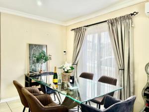 a dining room with a glass table and chairs at Forest View Villa in New Germany
