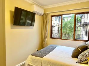 a bedroom with a bed with a flat screen tv on the wall at Forest View Villa in New Germany
