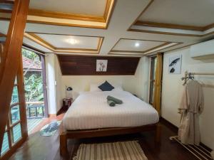 1 dormitorio con cama y ventana grande en ้hilly phitsano resort, 