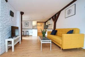 a living room with a yellow couch and a table at FV/ Mariacka 7 - Studio apartment -Katowice in Katowice