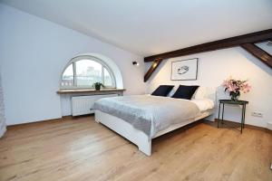 a bedroom with a white bed and a window at FV/ Mariacka 7 - Studio apartment -Katowice in Katowice